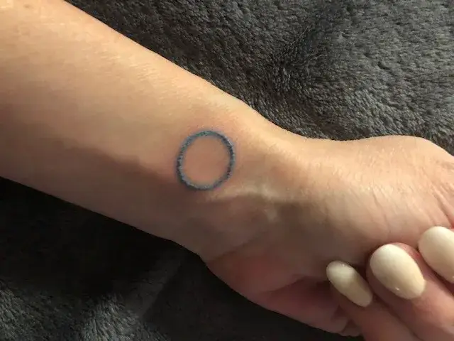 a hand with a blue circle on it