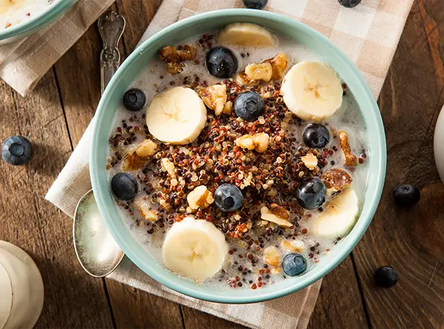 a bowl of oatmeal with fruit and milk