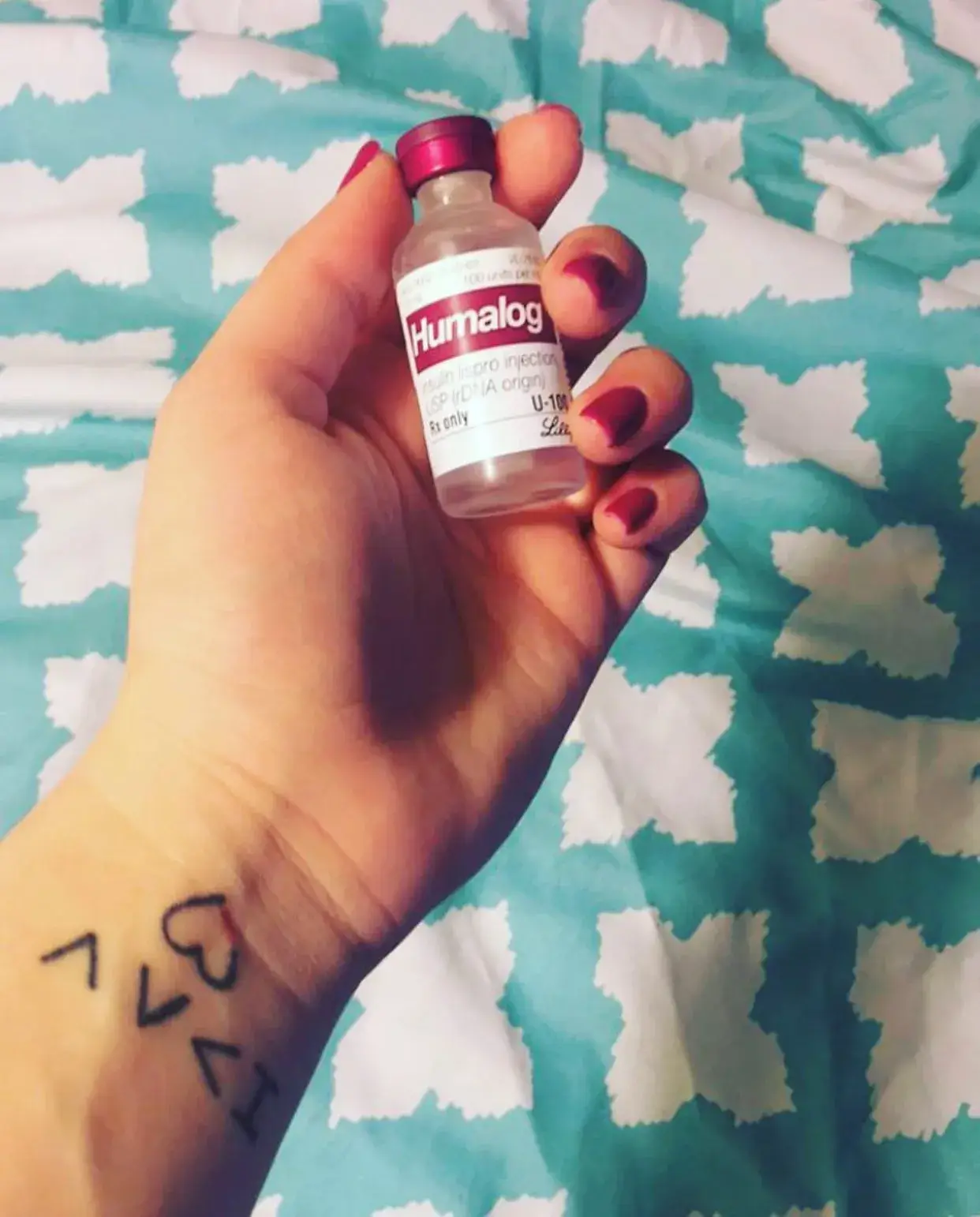 a hand holding a small bottle of medicine