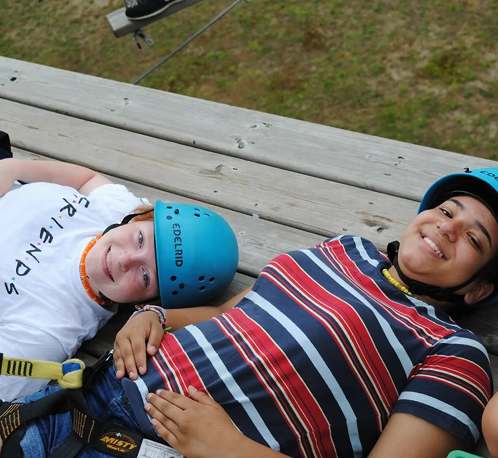 two people lying on a bench