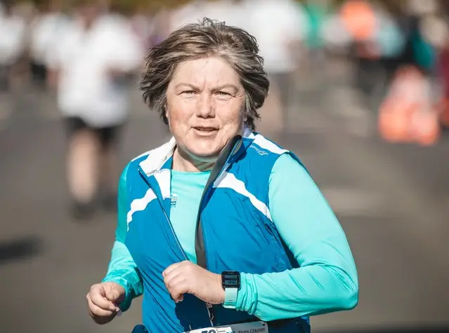 a woman running in a blue jacket