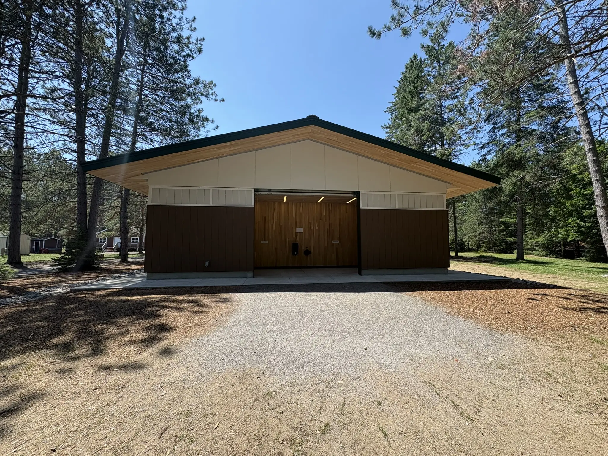 a building with a garage and trees in the background