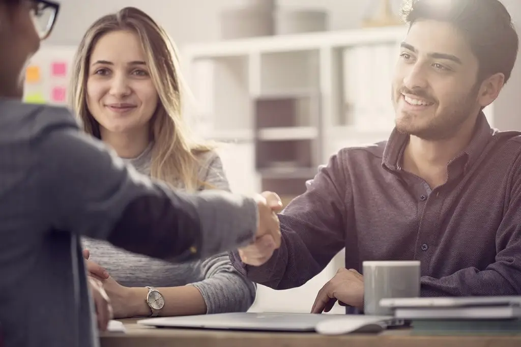 a man shaking hands with a woman